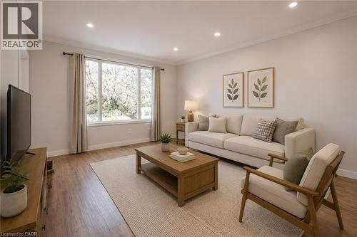 Living space featuring wood-finish flooring, recessed lighting, and a large multi-pane window - 204 Glow Avenue Unit# Upper, Hamilton, ON 