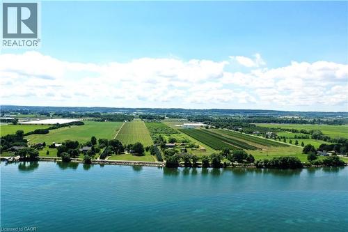 Expansive waterfront property featuring mature trees and a manicured lawn bordering the water - 3705 Service Road N, Beamsville, ON 
