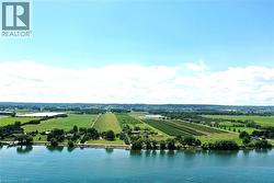Waterfront property featuring extensive green space, mature trees, and agricultural fields - 