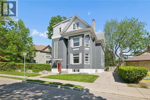 Multi-story residence featuring a gray exterior with white trim, a red entrance door, and a paved driveway - 149 Young Street, Kitchener, ON - Outdoor With Facade