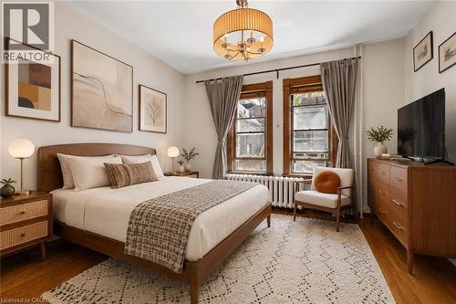 Bedroom featuring wood-finish flooring, and a ceiling-mounted chandelier - 149 Young Street, Kitchener, ON - Indoor Photo Showing Bedroom