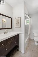 Bathroom with a dark wood vanity, white countertop, and brushed nickel fixtures - 