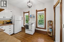 Kitchen featuring white cabinetry, light wood-finish countertops, and matching white appliances - 