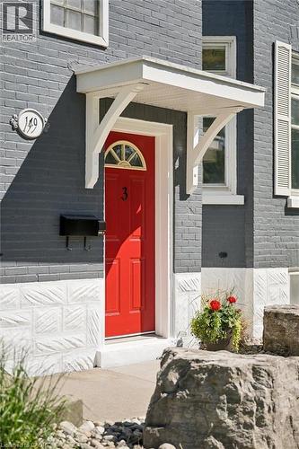 Red entry door with a sunburst transom window, sheltered by a white portico - 149 Young Street, Kitchener, ON - Outdoor