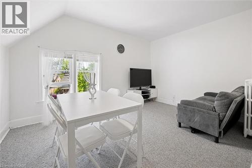 Bright interior space featuring a window with white sheers, light gray carpet, and white walls - 149 Young Street, Kitchener, ON - Indoor