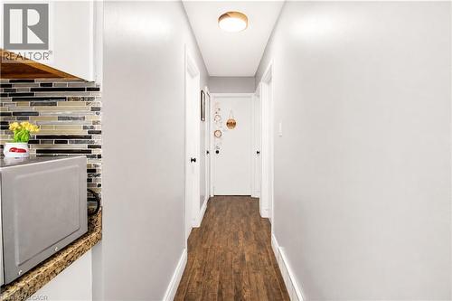 Hallway featuring wood-finish flooring, white baseboards, and a flush-mount ceiling light fixture - 103 Mcanulty Boulevard Unit# Upper, Hamilton, ON 