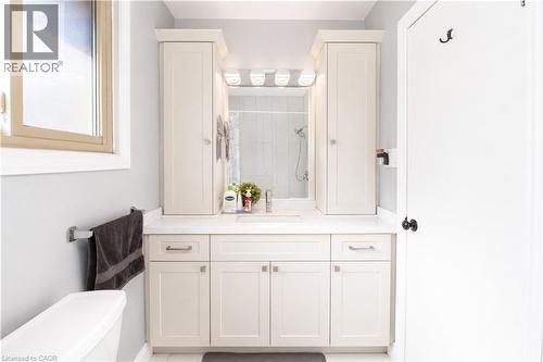 Bathroom featuring a light-colored vanity with a built-in sink, framed mirror, and integrated lighting - 103 Mcanulty Boulevard Unit# Upper, Hamilton, ON 