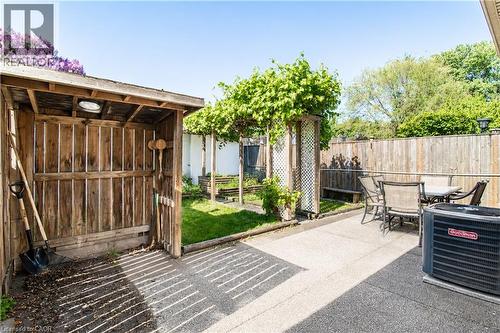 Outdoor patio featuring concrete surfacing, a built-in wooden storage shed, and a wooden fence perimeter - 103 Mcanulty Boulevard Unit# Upper, Hamilton, ON 