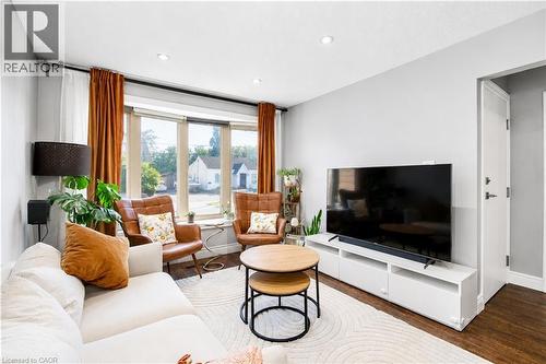 Bright living area featuring a large bay window, recessed lighting, and rich wood-finish flooring - 103 Mcanulty Boulevard Unit# Upper, Hamilton, ON 