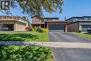 Brick facade residence featuring an attached two-car garage with a dark panel door, a paved driveway, and a front lawn with mature landscaping - 141 Lynndale Road, Simcoe, ON 