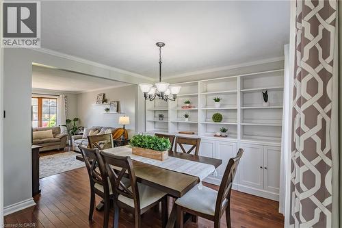 Dining area featuring a chandelier, wood-finish flooring, and crown molding - 141 Lynndale Road, Simcoe, ON 