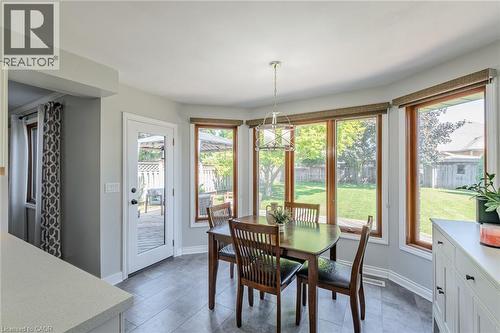 Dining area featuring a bay window with wood-finish trim, a full-light door providing exterior access, and tile flooring - 141 Lynndale Road, Simcoe, ON 