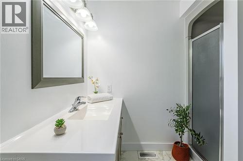 Bathroom featuring a single vanity with an integrated sink, polished chrome faucet, and a large framed mirror - 141 Lynndale Road, Simcoe, ON 