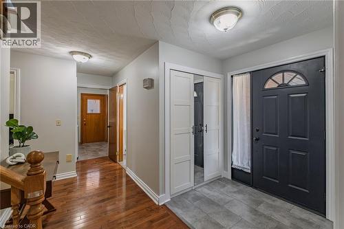 Entryway with dark paneled front door featuring an arched window detail and sidelight - 141 Lynndale Road, Simcoe, ON 