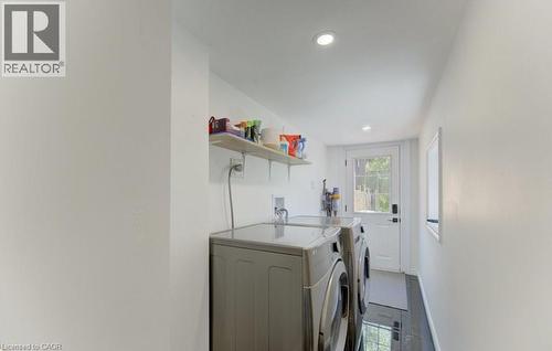 Functional laundry area featuring white walls, recessed lighting, and dark tile flooring - 11 Davidson Street, Cambridge, ON 