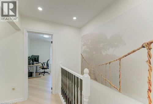 Hallway featuring recessed lighting, a decorative wall mural, and a white painted railing with dark balusters - 11 Davidson Street, Cambridge, ON 