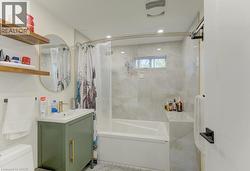 Contemporary bathroom featuring a white soaking tub with integrated shelving, light-toned patterned tile surround, and a compact window - 
