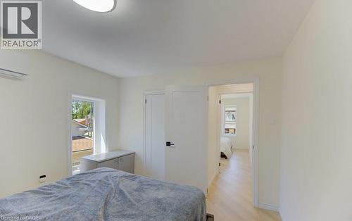 Bright room featuring light wood-finish flooring, a contemporary ceiling light fixture, a window with exterior views, and an internal entry door - 11 Davidson Street, Cambridge, ON 
