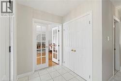 Foyer featuring white tile flooring, white baseboards, and neutral wall paint - 