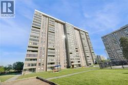 High-rise residential building featuring a brick and concrete facade with multiple balconies - 