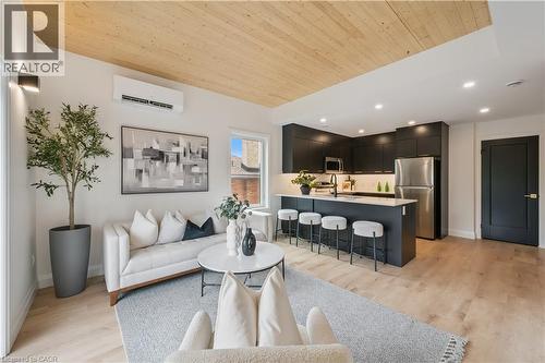 Open-concept living space with wood-finish flooring, a wood-paneled ceiling, and recessed lighting - 60 Arlington Boulevard Unit# 3, Kitchener, ON 