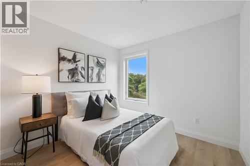 Bedroom featuring light wood-finish flooring, white walls, and a window offering a natural backdrop - 60 Arlington Boulevard Unit# 3, Kitchener, ON 