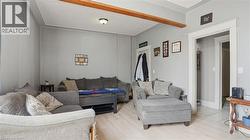 Expansive interior space featuring a prominent exposed wood beam, light wood-finish flooring, and a neutral wall color - 