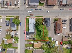 Aerial view highlighting a property with a significant green space, a paved surface, and two visible structures - 