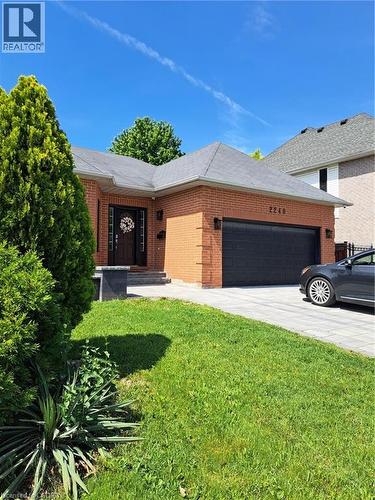 Brick exterior with a dark gray shingled roof - 2240 Headon Road Unit# Lower, Burlington, ON 