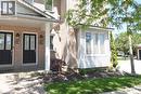 Brick facade with a covered entry featuring a white column and two black panel doors with glass inserts - 2 Harbour Drive Unit# 17, Stoney Creek, ON 