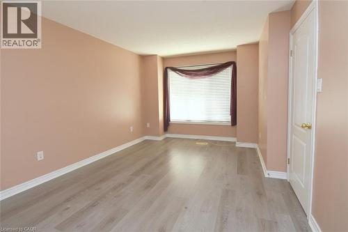 Spacious room featuring light wood-finish flooring, neutral wall tones, and white baseboards - 2 Harbour Drive Unit# 17, Stoney Creek, ON 