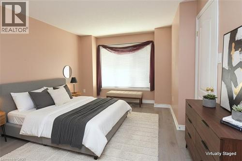 Spacious room featuring wood-finish flooring, light-colored walls, and a large window with horizontal blinds - 2 Harbour Drive Unit# 17, Stoney Creek, ON 