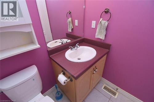 Bathroom featuring a vanity with a white basin sink, polished chrome faucet, and integrated countertop - 2 Harbour Drive Unit# 17, Stoney Creek, ON 