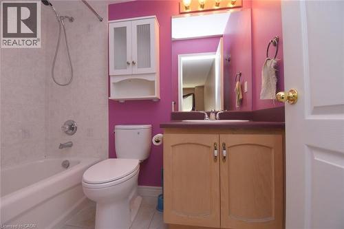 Full bathroom featuring a white bathtub with a tiled surround, a toilet, and a light wood-finish vanity with a built-in sink and an overhead mirrored medicine cabinet - 2 Harbour Drive Unit# 17, Stoney Creek, ON 