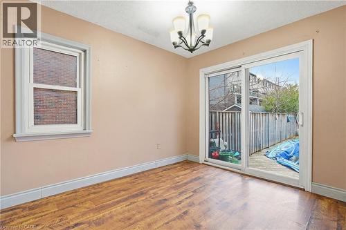 Dining room featuring wood finished floors, a chandelier, and a textured ceiling - 549 Weber Street E, Kitchener, ON 