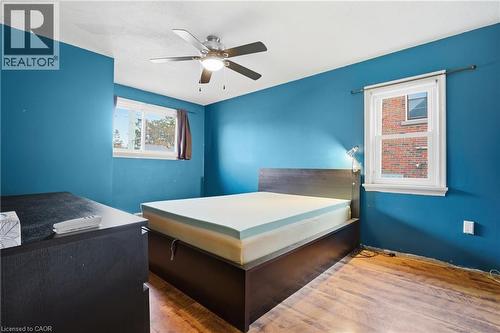 Bedroom featuring wood finished floors, ceiling fan, and an office area - 549 Weber Street E, Kitchener, ON 