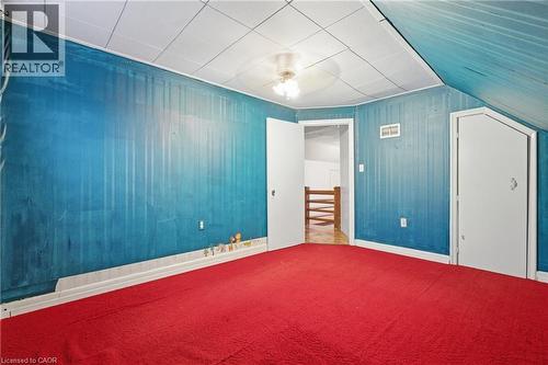 Unfurnished bedroom featuring wood walls, carpet, and ceiling fan - 549 Weber Street E, Kitchener, ON 