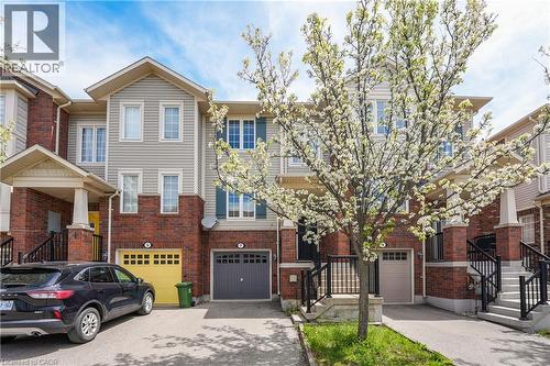 Brick and siding exterior featuring individual garage access and a dedicated driveway - 7 Hepworth Crescent, Ancaster, ON 