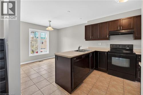 Kitchen featuring dark wood-finish cabinetry, a black electric range, and a dual-basin stainless steel sink - 7 Hepworth Crescent, Ancaster, ON 