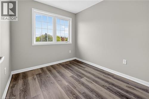 Bright interior space featuring wood-finish flooring, light grey wall paint, and white trim - 7 Hepworth Crescent, Ancaster, ON 