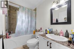 Bathroom featuring a vanity with an integrated sink, a framed mirror, and a three-light fixture - 