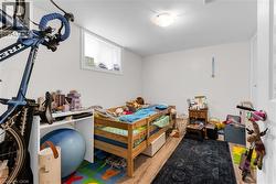 Lower-level room with wood-finish flooring, white walls, and a single window - 