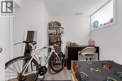 Interior room featuring light wood-finish flooring, white walls, and a built-in window with white trim - 