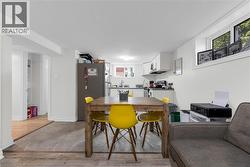 Open-concept living area featuring wood-finish flooring, white walls, and recessed lighting - 