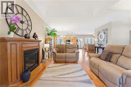 Living room featuring a wood-finish  gas fireplace,  and vaulted ceilings - 5 Coastal Court, Port Dover, ON 