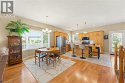 Open-concept kitchen and dining area with hardwood flooring - 
