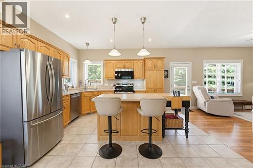 Kitchen featuring wood cabinetry, stainless steel appliances, and a central island with bar seating - 5 Coastal Court, Port Dover, ON 