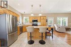 Kitchen featuring wood cabinetry, stainless steel appliances, and a central island with bar seating - 