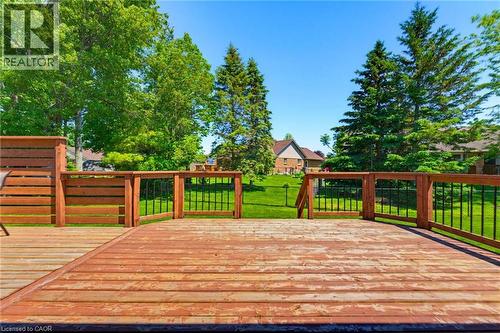 Spacious wood deck with perimeter railing featuring black balusters, overlooking a manicured lawn - 5 Coastal Court, Port Dover, ON 