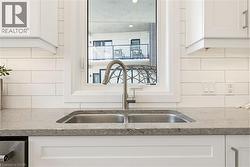 Double-basin stainless steel sink with a gooseneck faucet set into a speckled countertop - 